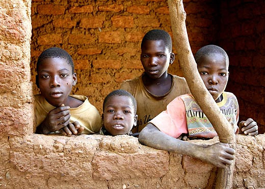 A group of boys watching a dance ceremony in their village