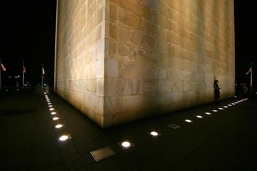 Illuminated by spotlights, the Washington Monument gleams against the nighttime sky